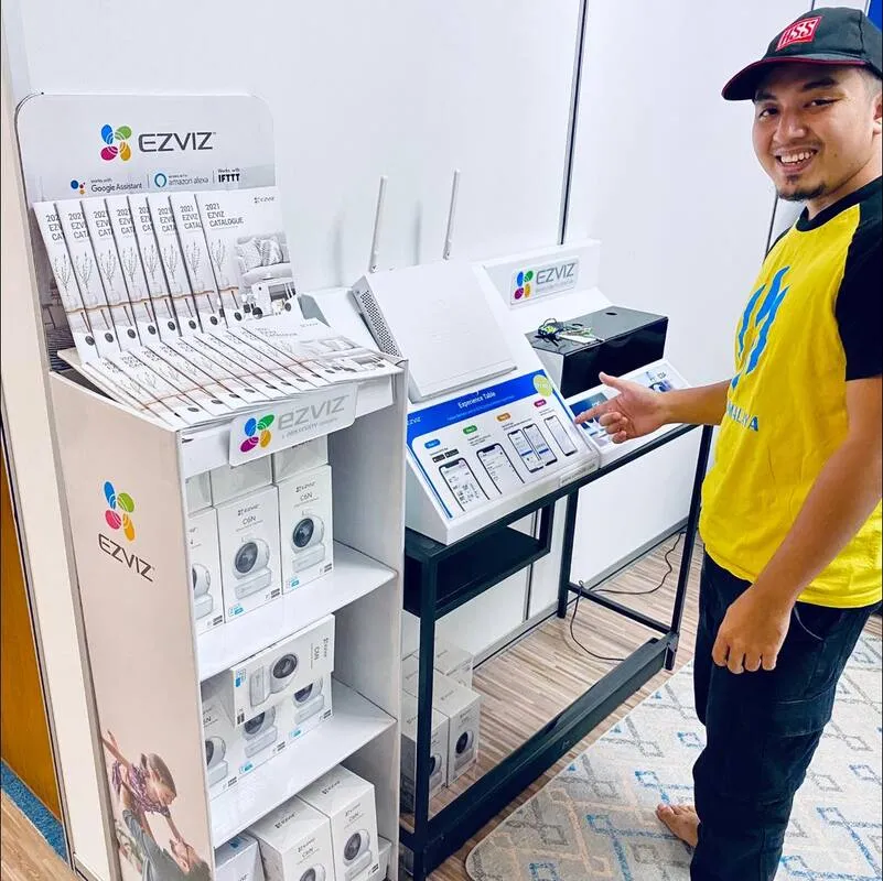 Afiq menunjukkan unit kamera EZVIZ di showroom HSS